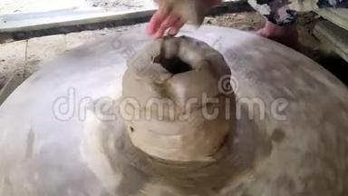 巨锅形状旋转在陶轮老女人添加泥卷